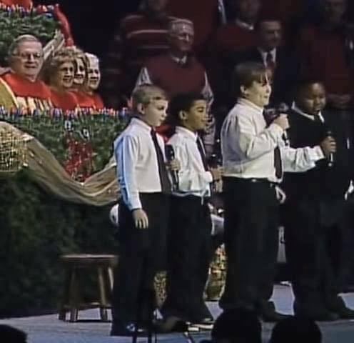 Four boys singing in church is the funniest thing you’ll see today. Keep an eye on the boy in the vest!