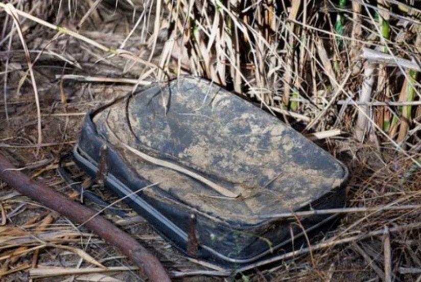 This woman came across an old, filthy luggage in a bush